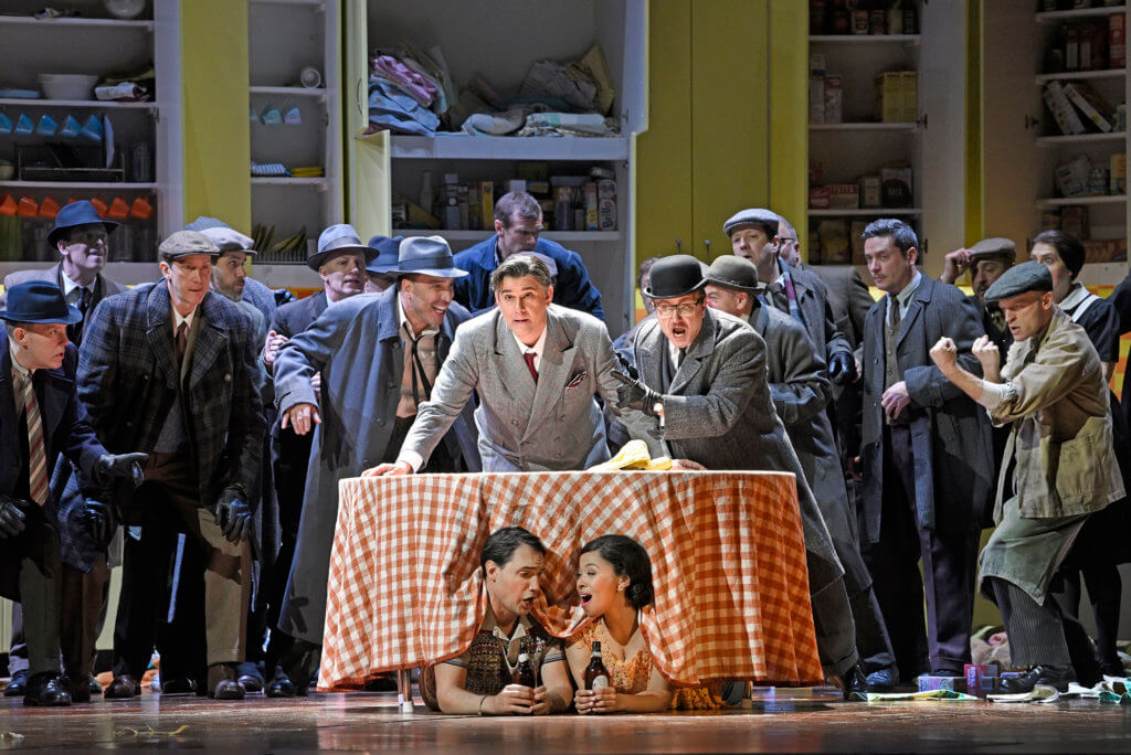 Francesco Demuro as Fenton and Golda Schultz as Nannetta (under table) and (left to right, behind table) Richard Bernstein as Pistola, Juan Jesús Rodríguez as Ford, and Tony Stevenson as Dr. Caius in Verdi's "Falstaff." 